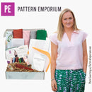 Woman standing next to a box from Pattern Emporium with fabric and sewing supplies.