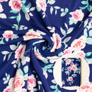 Floral fabric with pink roses and green leaves on a navy blue background