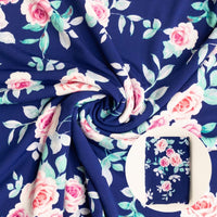 Floral fabric with pink roses and green leaves on a navy blue background