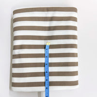 Brown and white striped fabric with a measuring tape on a white background