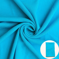 A turquoise blue fabric shown draped with a small circular inset of folded fabric.