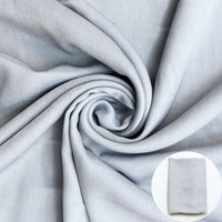 Gray fabric shown draped with a small circular inset of folded fabric.