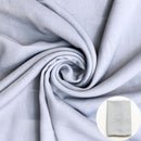 Gray fabric shown draped with a small circular inset of folded fabric. 