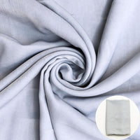 Gray fabric shown draped with a small circular inset of folded fabric. 