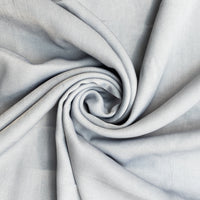 A close-up of a soft gray viscose rayon twill fabric, showcasing the fine diagonal weave and smooth texture.