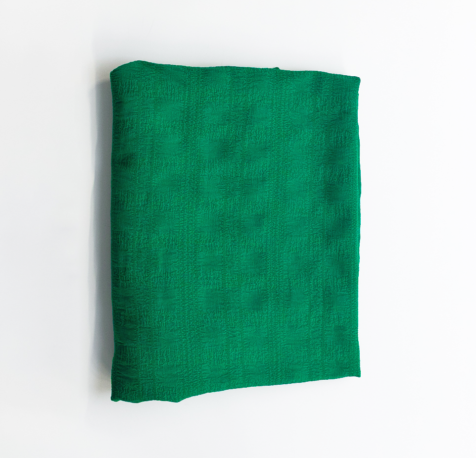 Folded green fabric on a white background