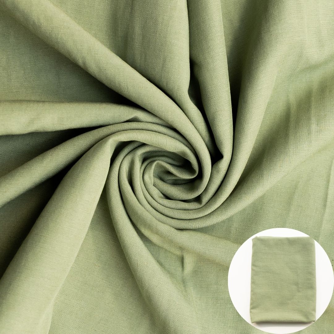 Green fabric shown draped with a small circular inset of folded fabric.