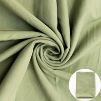Green fabric shown draped with a small circular inset of folded fabric.