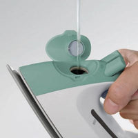 Hand filling up a  green iron with water. 