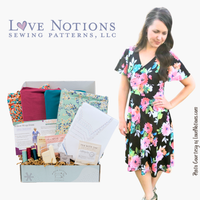 Woman in a floral dress standing next to a sewing kit with 'Love Notions' branding.