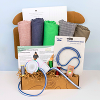 Crafting kit with fabric, tools, and instructions on a white surface