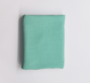 Folded mint green fabric on a light gray background