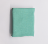Folded mint green fabric on a light gray background