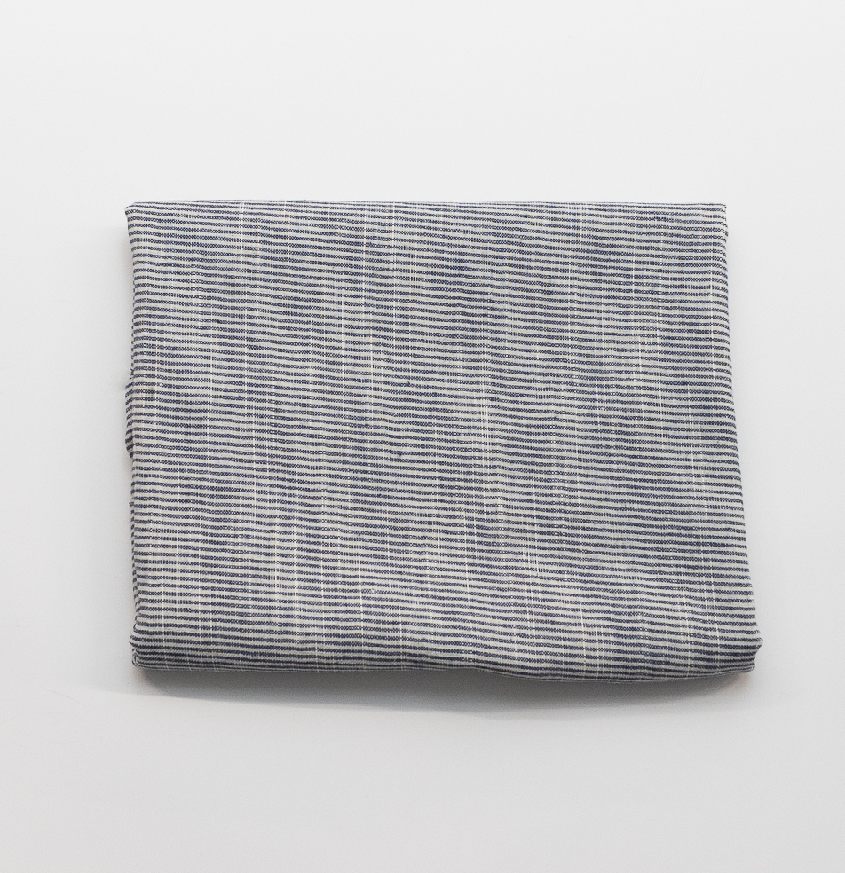 Folded fabric with a bankers stripe pattern on a light gray background