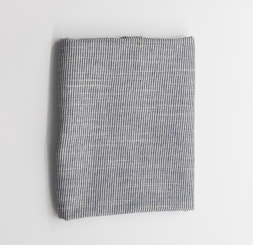 Folded fabric with a bankers stripe pattern on a light gray background
