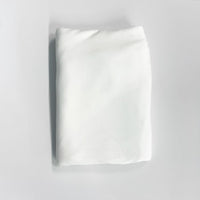 White folded fabric a light gray background