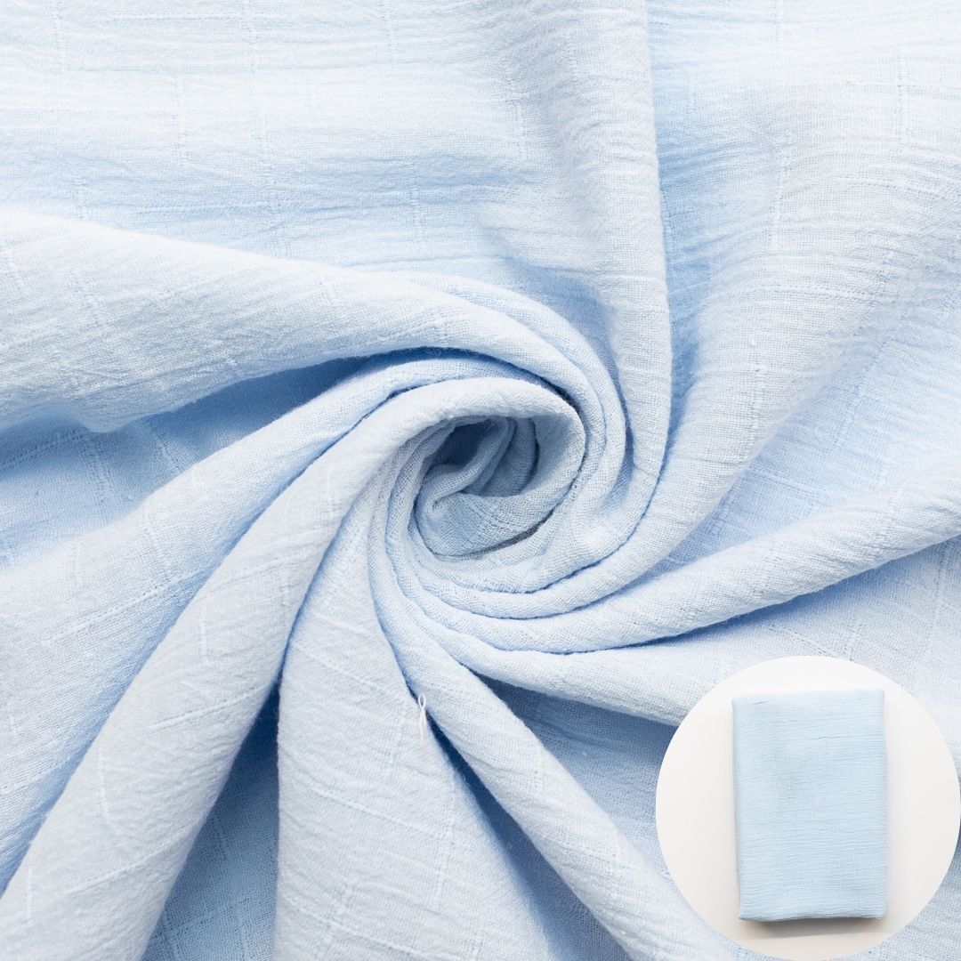 Light pale blue fabric shown draped with a small circular inset of folded fabric.