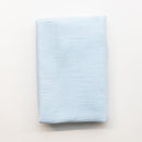 A folded piece of light pale blue fabric displayed flat against a clean white background.