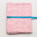 Pink fabric with a subtle pattern on a white background, measured by a blue ruler.