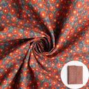 A red fabric featuring a floral pattern, shown draped with a small circular inset of folded fabric.