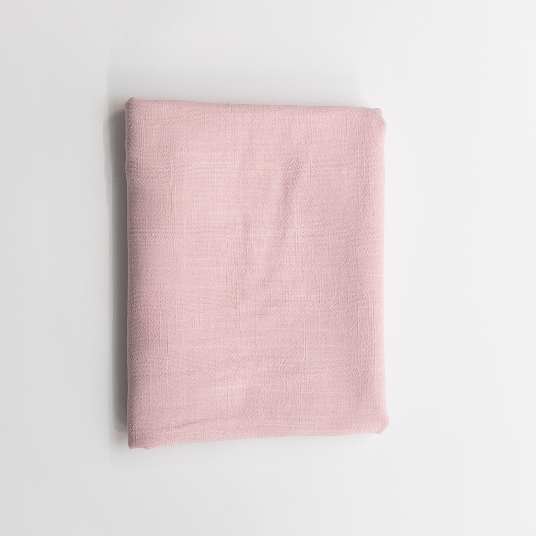 Folded pink fabric on a light gray background