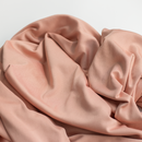Dusty peach jersey knit fabric draped in soft folds