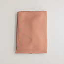 Dusty peach jersey knit fabric, folded flat