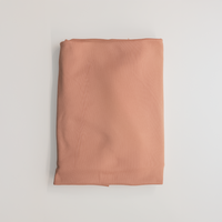 Dusty peach jersey knit fabric, folded flat