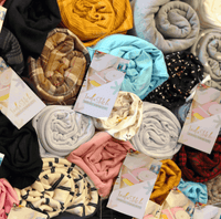 Pile of colorful rolled fabric scraps with IndieStitch tags